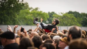 A fan crowd-surfs at an IDLES festival show, capturing IDLES live in 2026