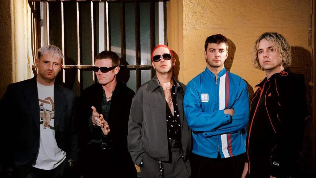 Fontaines D.C. stand against a yellow wall in a 2026 press photograph