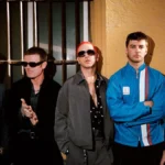 Fontaines D.C. stand against a yellow wall in a 2026 press photograph